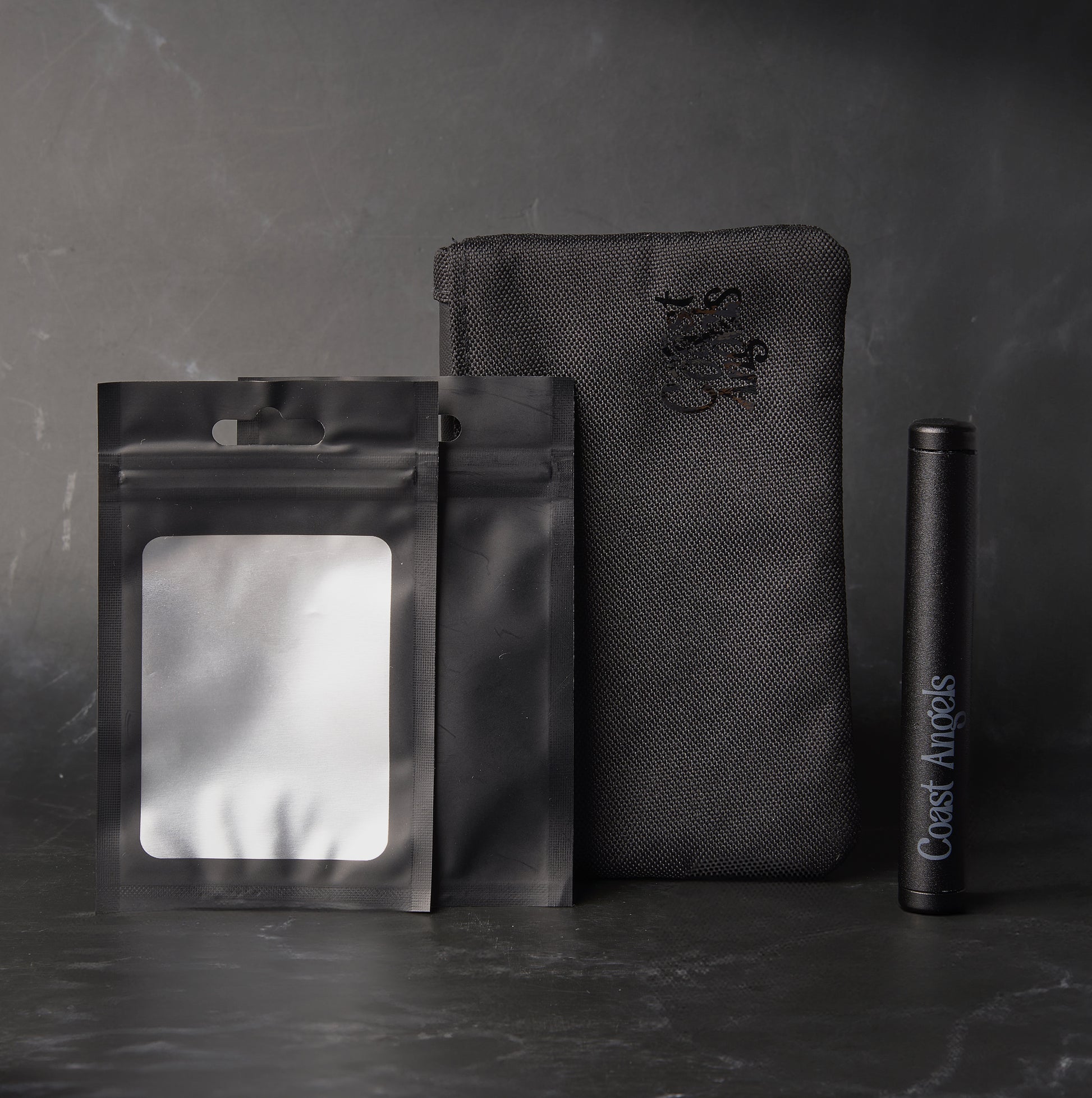 Coast Angels Camden Smell Proof Pouch set against a black marbled background, showcasing the stylish design with Doob Tube and two small odor-proof bags.