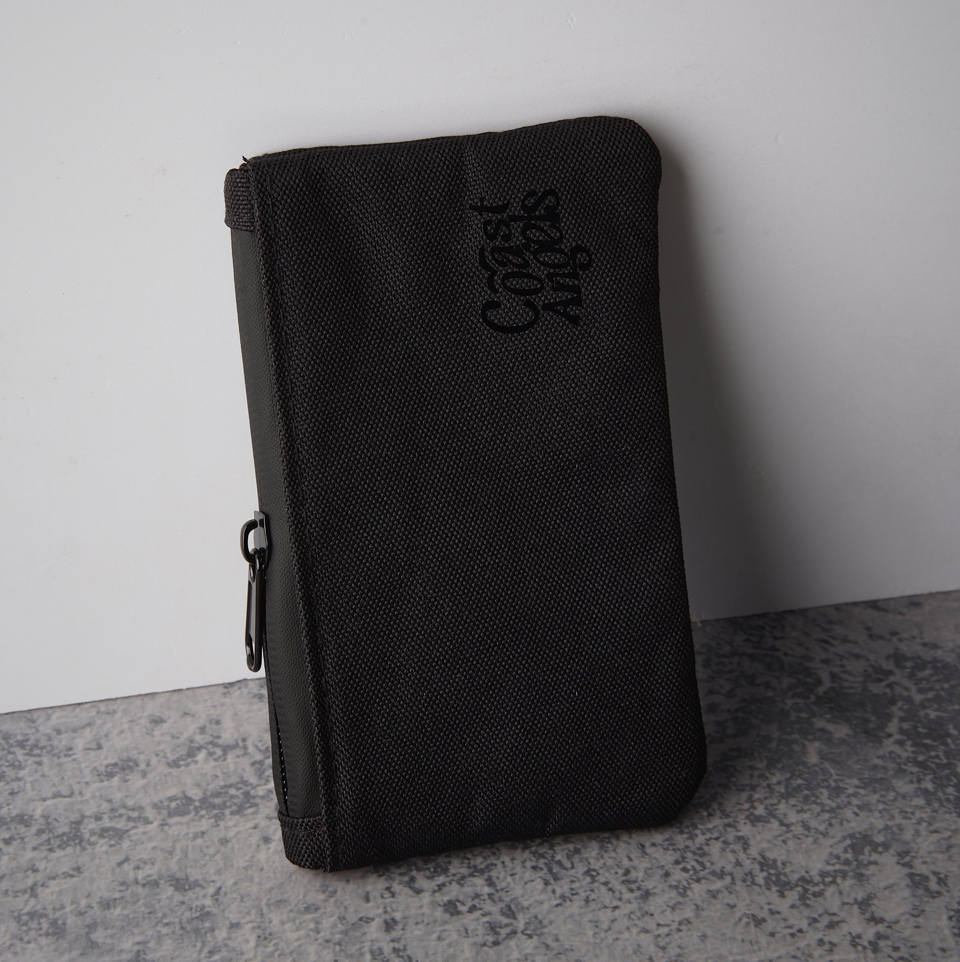 Coast Angels Camden Smell Proof Pouch standing against a wall, highlighting detailed design and waterproof zipper.