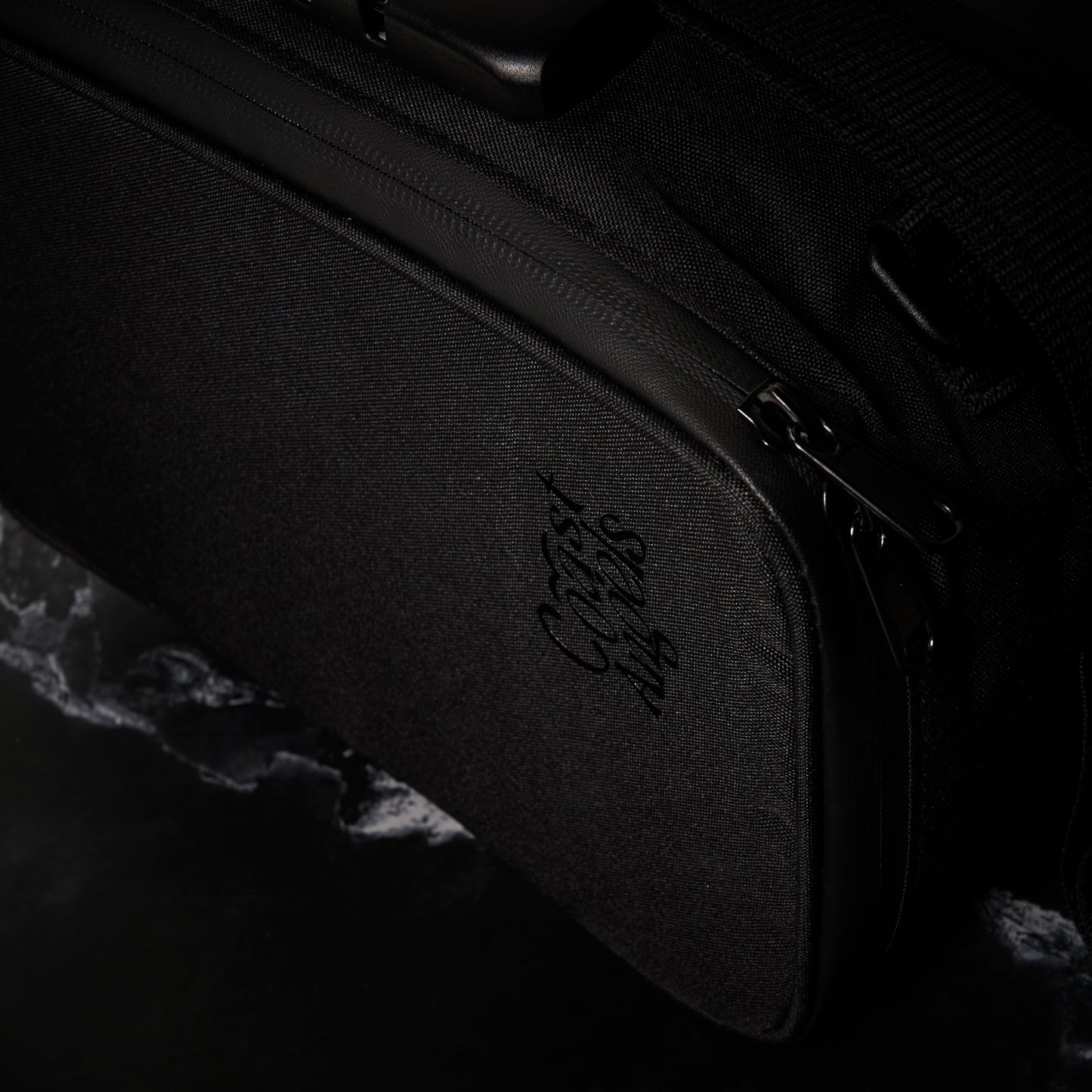 Close-up of Coast Angels Dalston Smell Proof Bag on a dark background, highlighting the waterproof zipper and durable design.