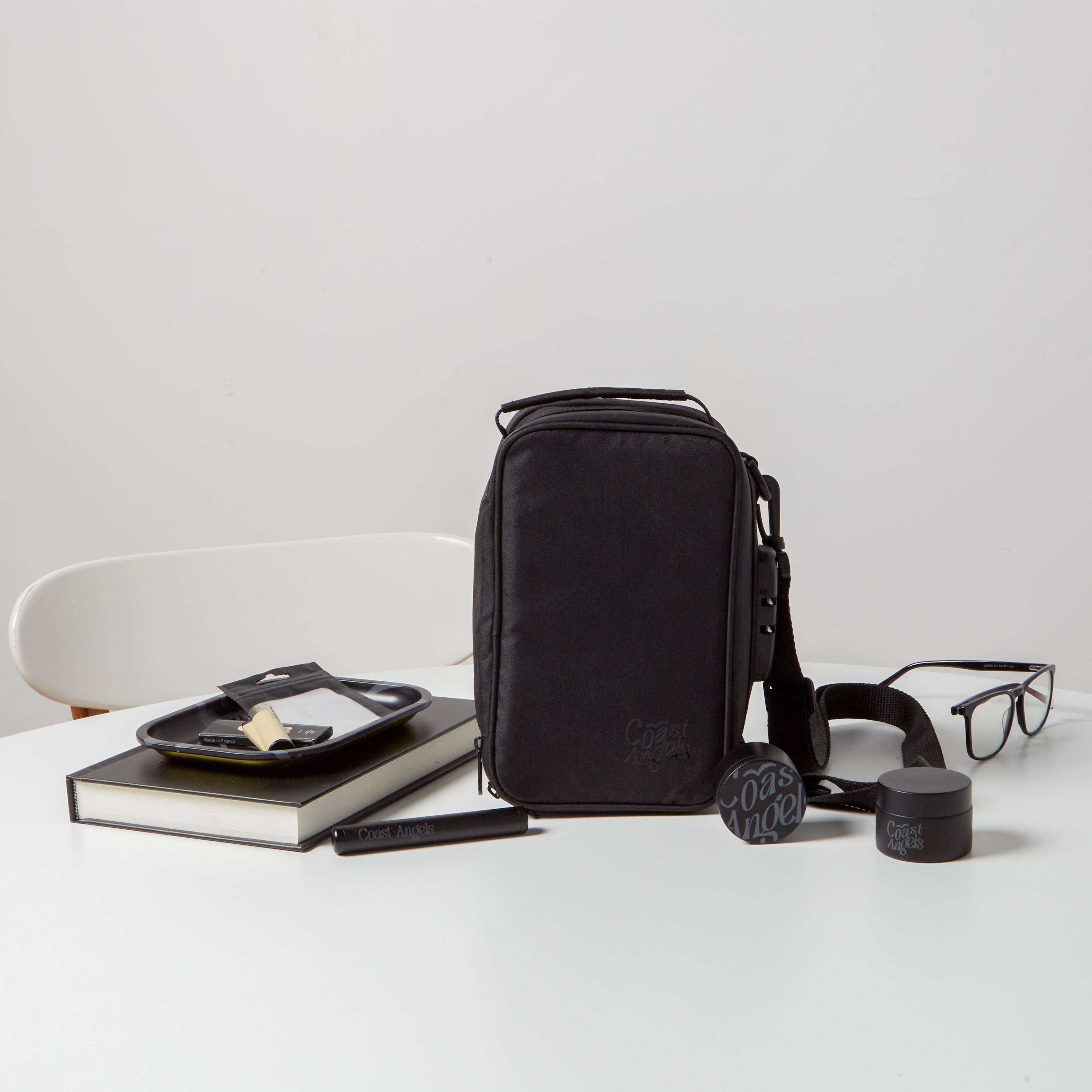 Coast Angels Hackney Kit lineup on a white table, displayed alongside a black hardcover book and black glasses, highlighting the kit’s sleek, stylish aesthetic.