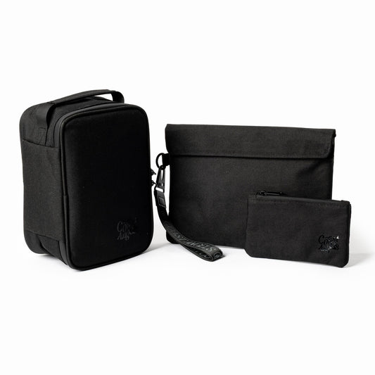 Set of black Coast Angels travel bags with a visible brand logo on a white background