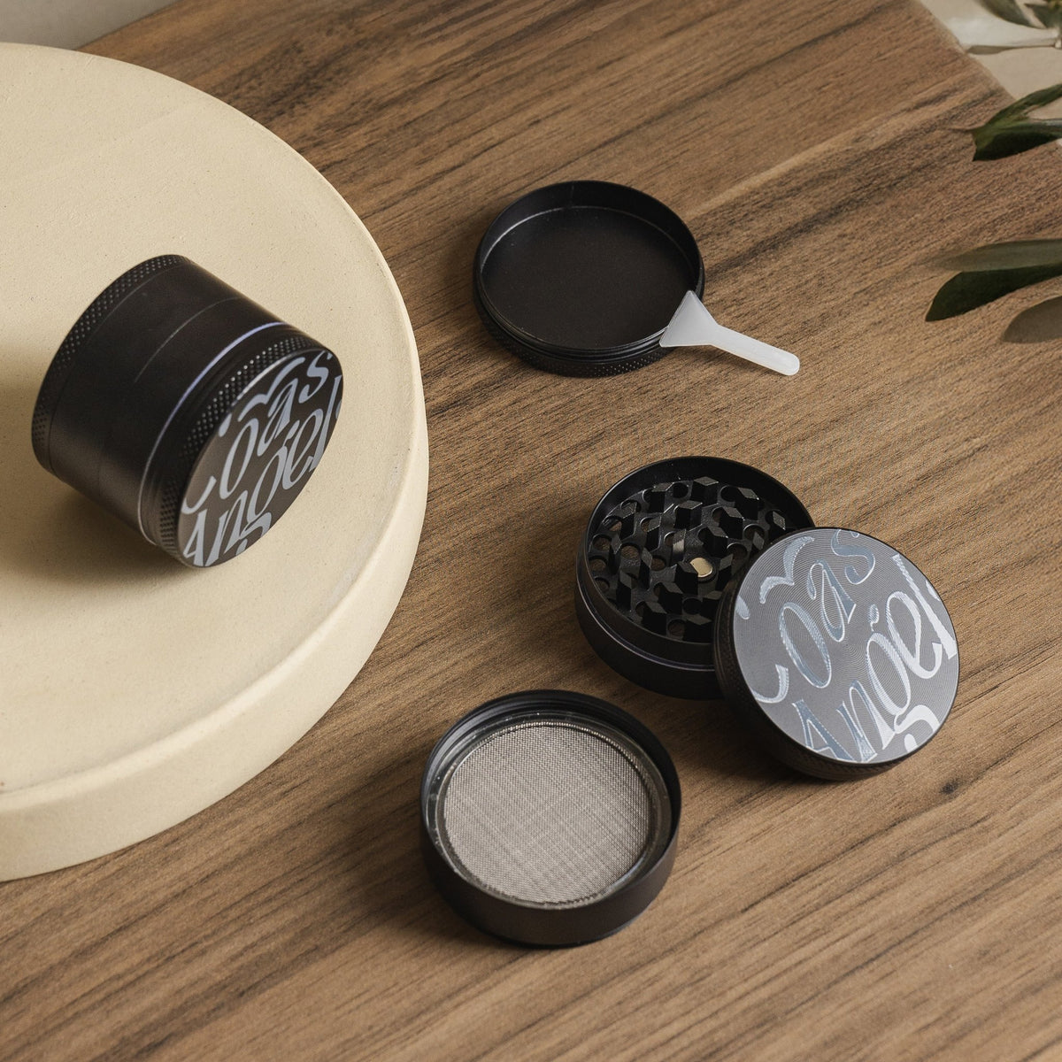 Black grinder with decorative top on a wooden surface